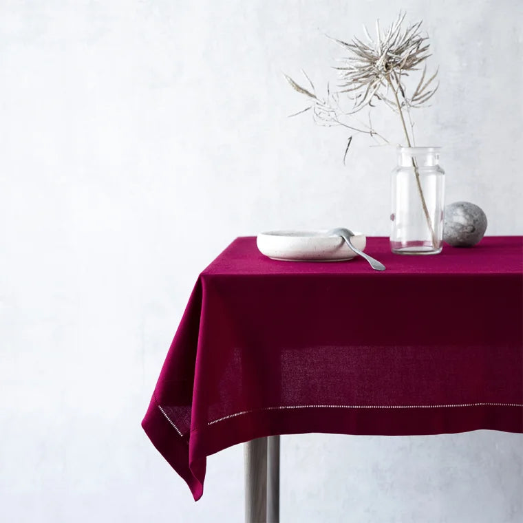 Mørkerød dug med broderet hulsøm